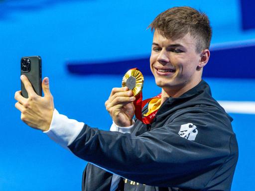 Taliso Engel vom deutschen Para-Team fotografiert sich mit seiner Goldmedaille