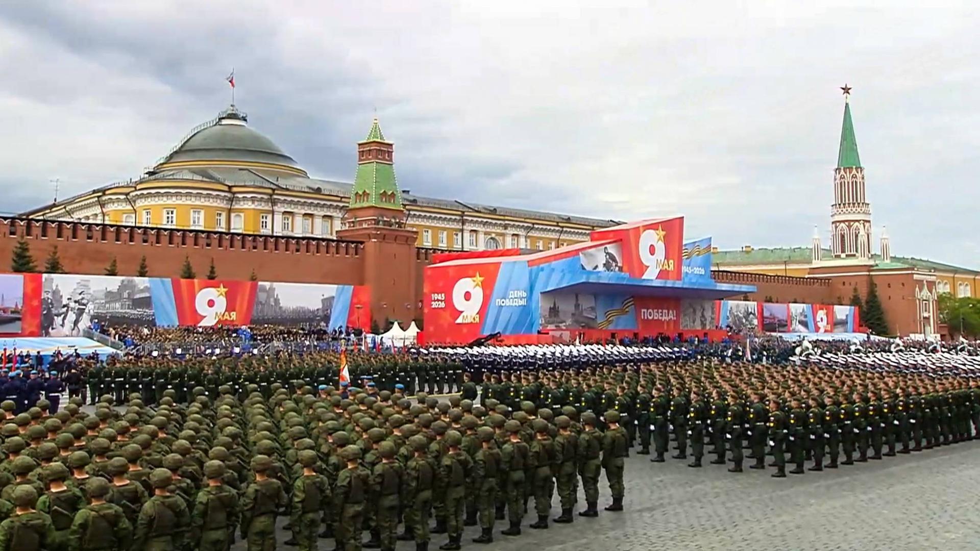 Soldaten stehen aufgereiht auf dem Roten Platz in Moskau vor einer Tribüne.