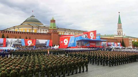 Soldaten stehen aufgereiht auf dem Roten Platz in Moskau vor einer Tribüne.