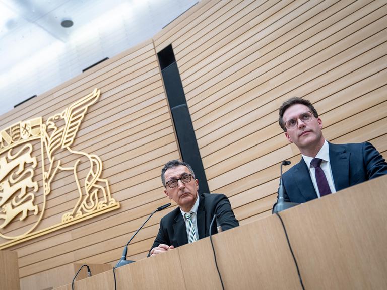 Cem Özdemir (l.), Spitzenkandidat der Grünen, und Manuel Hagel, Spitzenkandidat der CDU, sitzen auf der Landespressekonferenz im Landtag am Wahlabend auf dem Podium.