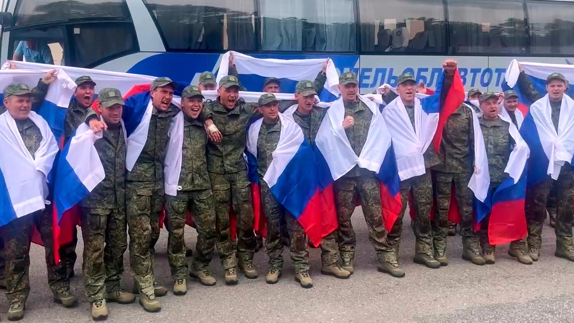 Auf diesem Foto vom Pressedienst des russischen Verteidigungsministeriums posieren russische Soldaten mit Nationalflaggen, nachdem sie im Rahmen eines Kriegsgefangenenaustauschs aus der Gefangenschaft zurückgekehrt sind. 