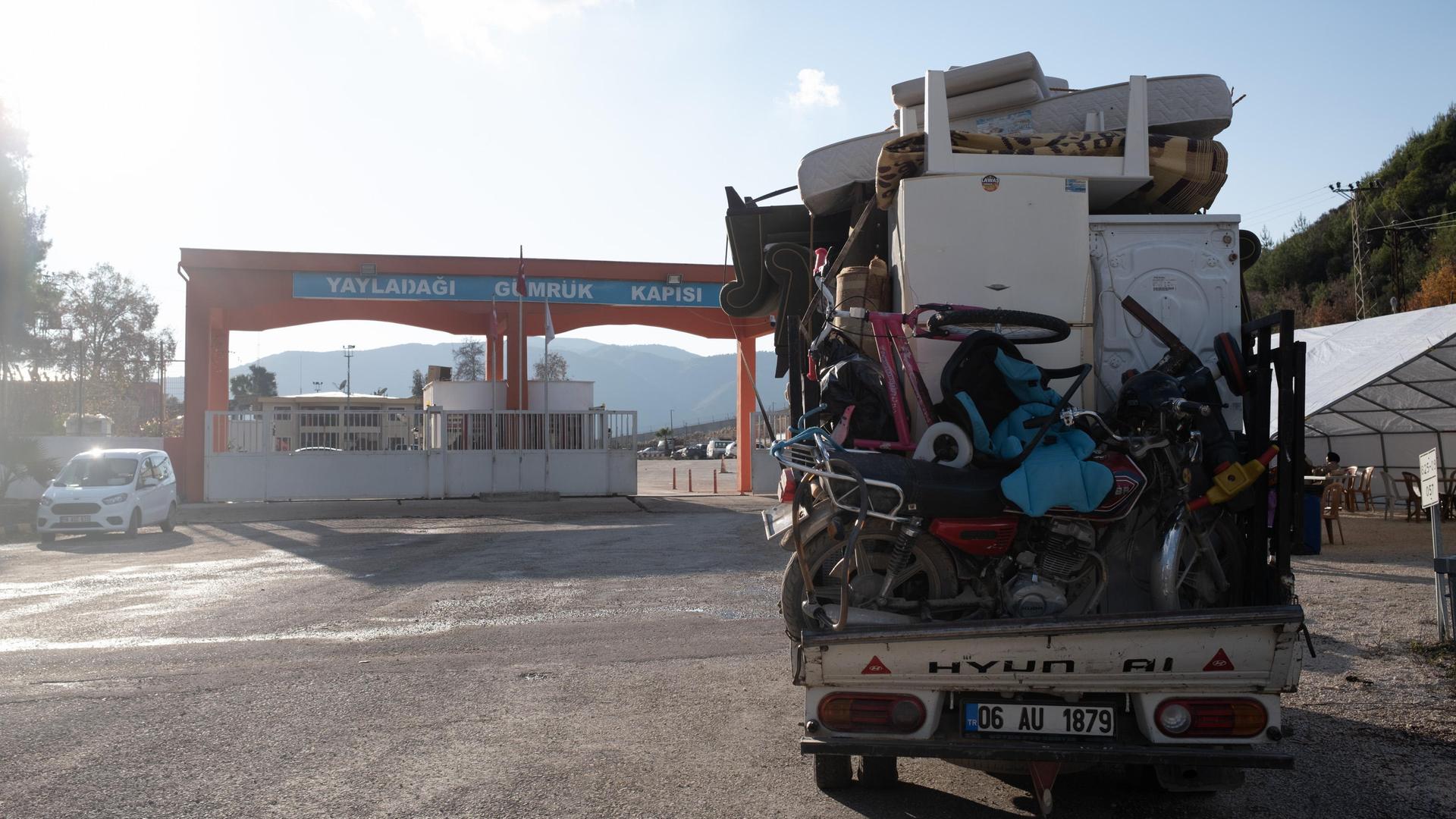 Ein Bus voller Möbel steht vor einem türkisch-syrischen Grenzübergang