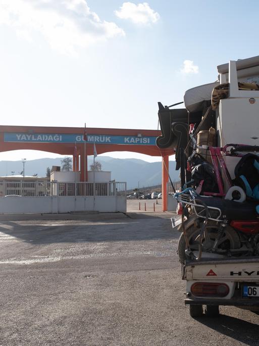 Ein Bus voller Möbel steht vor einem türkisch-syrischen Grenzübergang