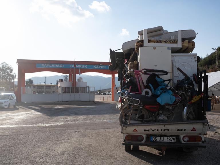 Ein Bus voller Möbel steht vor einem türkisch-syrischen Grenzübergang