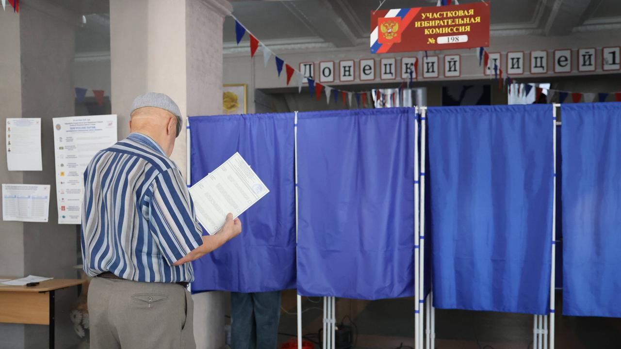 Ein Mann betritt eine Wahlkabine in einem Wahllokal während der Wahlen zur neunten Staatsduma, dem Unterhaus des russischen Parlaments, in Donezk, Russland.