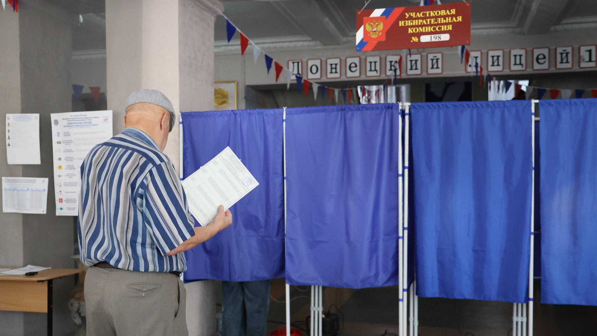 Ein Mann betritt eine Wahlkabine in einem Wahllokal während der Wahlen zur neunten Staatsduma. Ein Mann betritt eine Wahlkabine in einem Wahllokal während der Wahlen zur neunten Staatsduma.