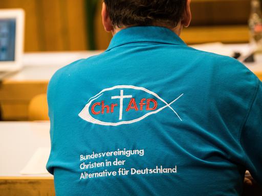 Ein Parteimitglied trägt ein Polohemd mit der Aufschrift "Bundesvereinigung Christen in der Alternative für Deutschland".