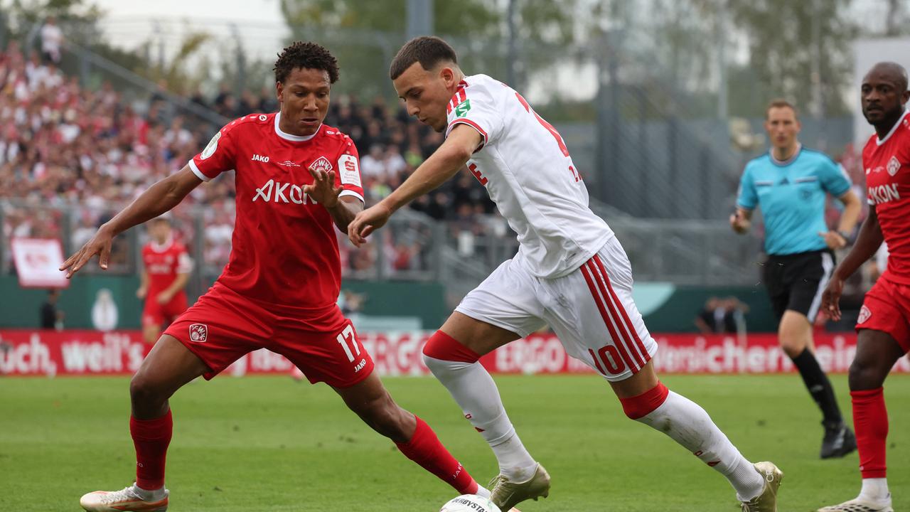 24.08.2026, Bayern, Würzburg: Fußball, Männer: DFB-Pokal, Würzburger Kickers - 1. FC Köln, 1. Runde, AKON Arena, Said El Mala (r) von Köln und Liam Omore von Würzburg, kämpfen um den Ball. Foto: Karl-Josef Hildenbrand/dpa 