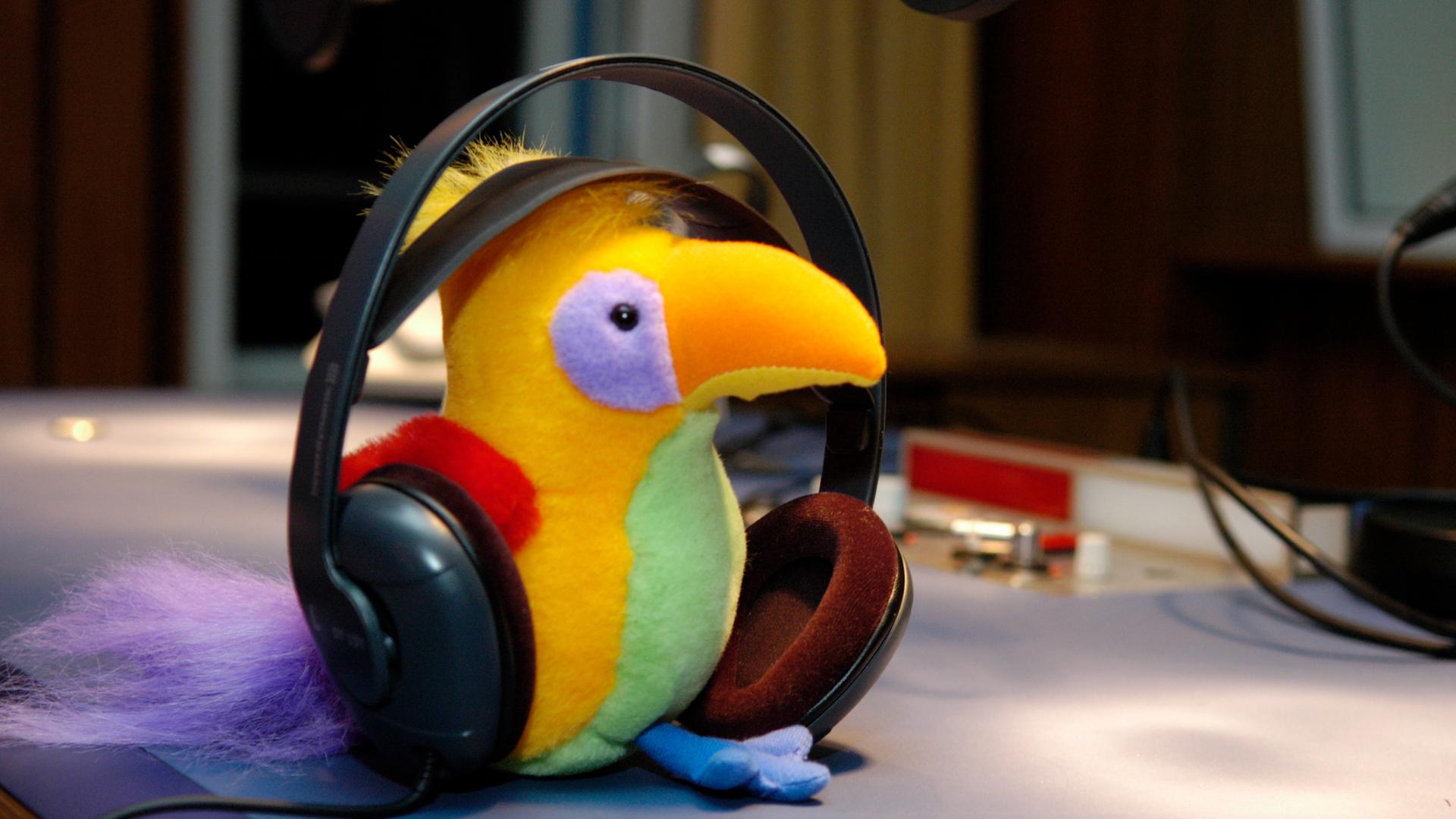 Der Kakadu als Plüschtier mit Kopfhörern.
