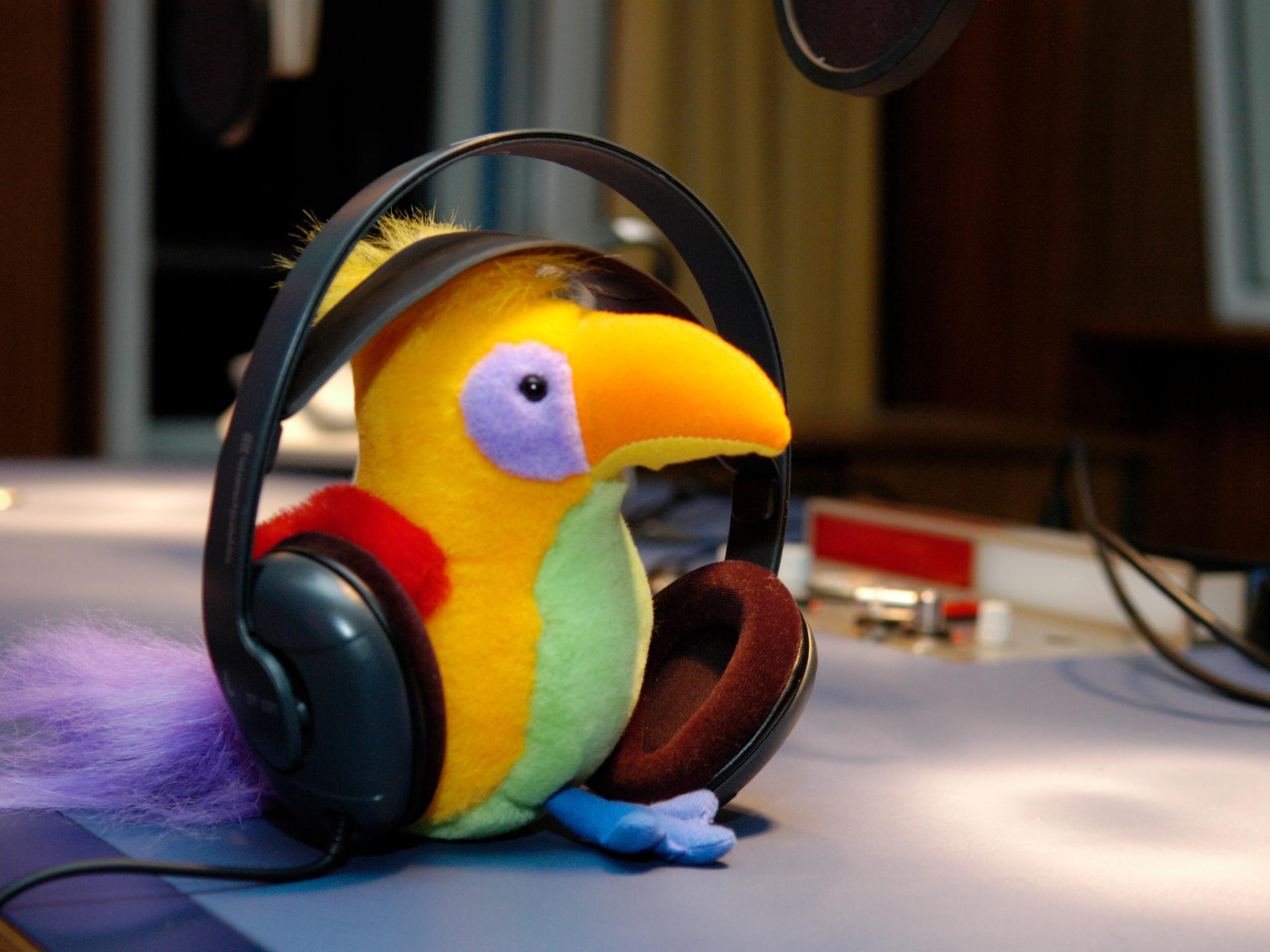 Der Kakadu als Plüschtier mit Kopfhörern.
