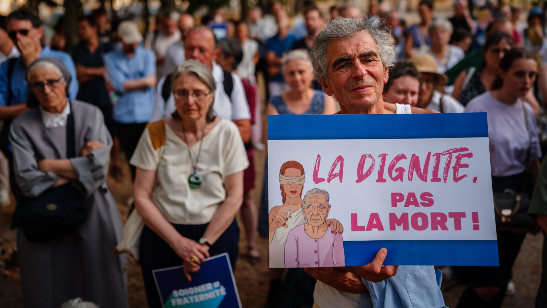 Am 15. Juli 2026 nehmen Demonstranten in der Nähe der französischen Nationalversammlung in Paris an einer Kundgebung gegen Sterbehilfe und assistierten Suizid teil. Ein Demonstrant hält ein Schild mit der Aufschrift "Würde statt Tod". Am 15. Juli 2026 nehmen Demonstranten in der Nähe der französischen Nationalversammlung in Paris an einer Kundgebung gegen Sterbehilfe und assistierten Suizid teil. Ein Demonstrant hält ein Schild mit der Aufschrift "Würde statt Tod".