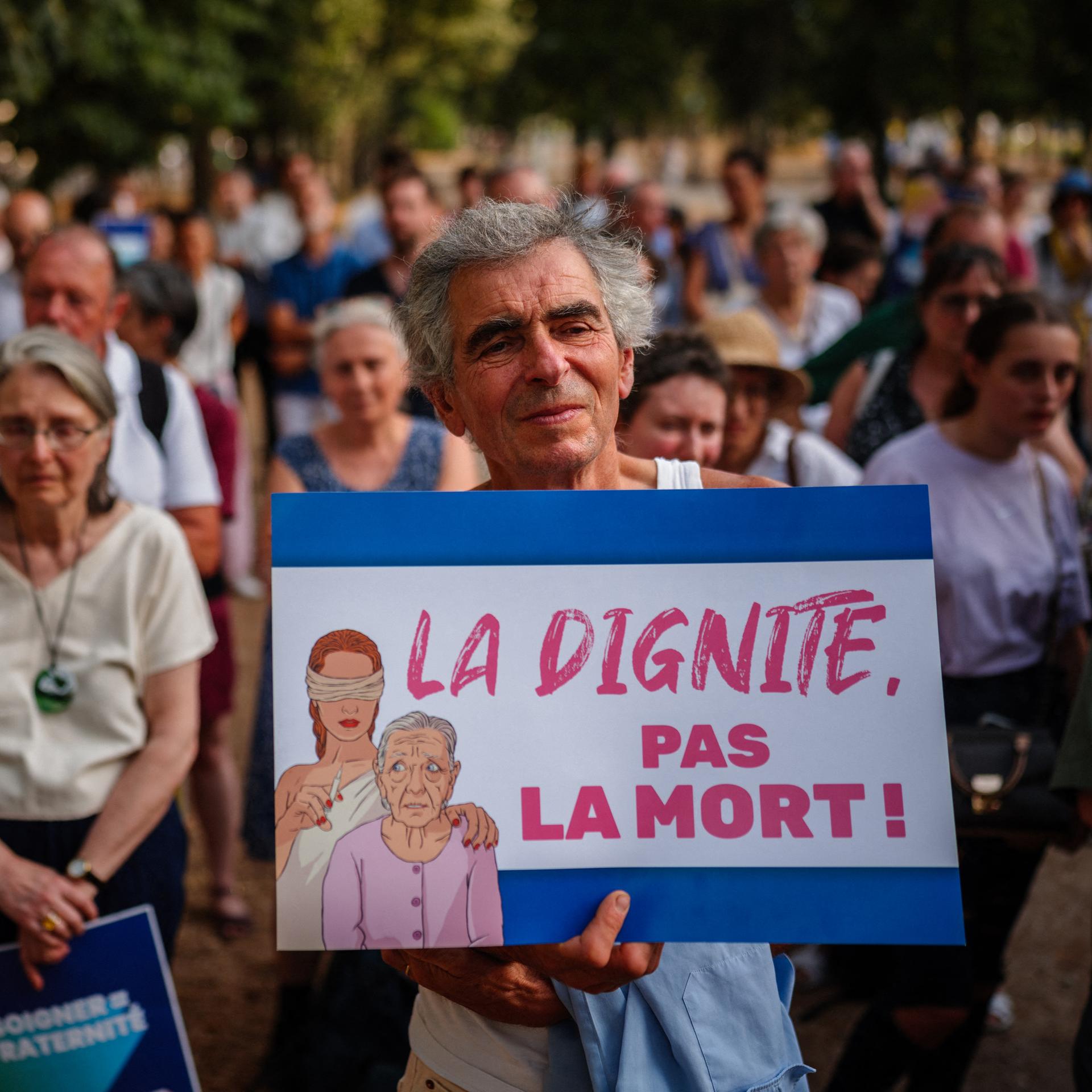Am 15. Juli 2026 nehmen Demonstranten in der Nähe der französischen Nationalversammlung in Paris an einer Kundgebung gegen Sterbehilfe und assistierten Suizid teil. Ein Demonstrant hält ein Schild mit der Aufschrift "Würde statt Tod".
