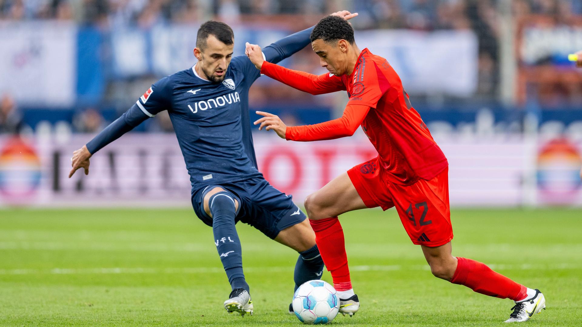 Bochums Erhan Masovic (l) und Münchens Jamal Musiala kämpfen um den Ball.