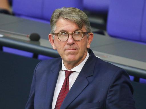 Wolfram Weimer steht im Sitzungssaal des Deutschen Bundestages und blickt gespannt zur Seite.