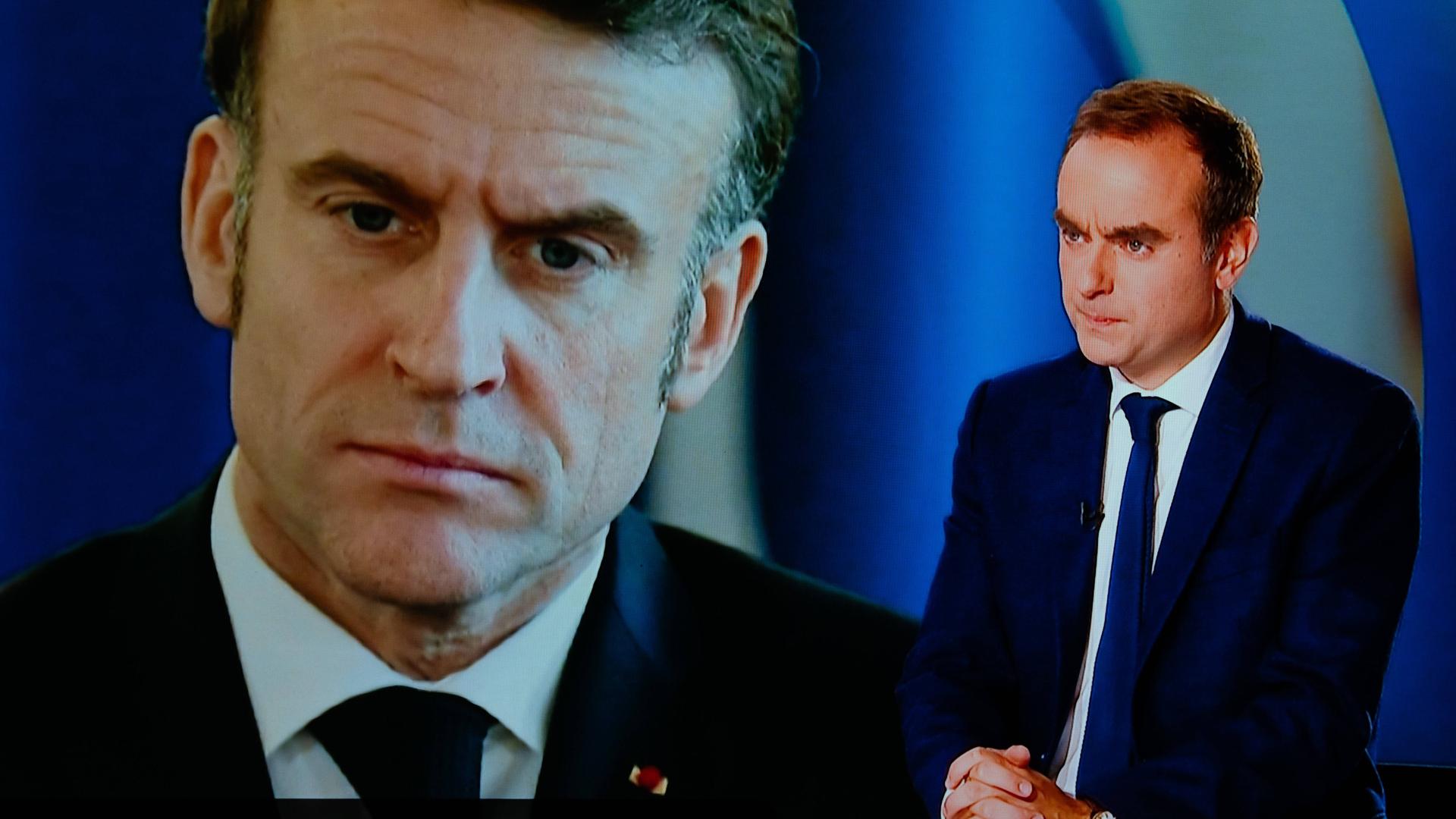 Frankreichs Premier Sebastien Lecornu steht in einem Fernsehstudio, im Hintergrund ist Präsident Macron auf einen Bildschirm projiziert. 
