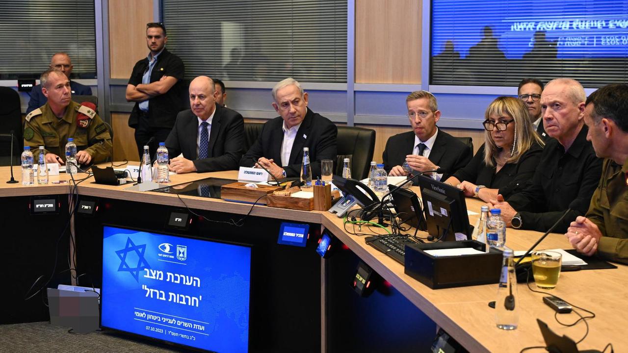 Benjamin Netanjahu sitzt mit Ministern und Militärs am Kabinetts-Tisch.