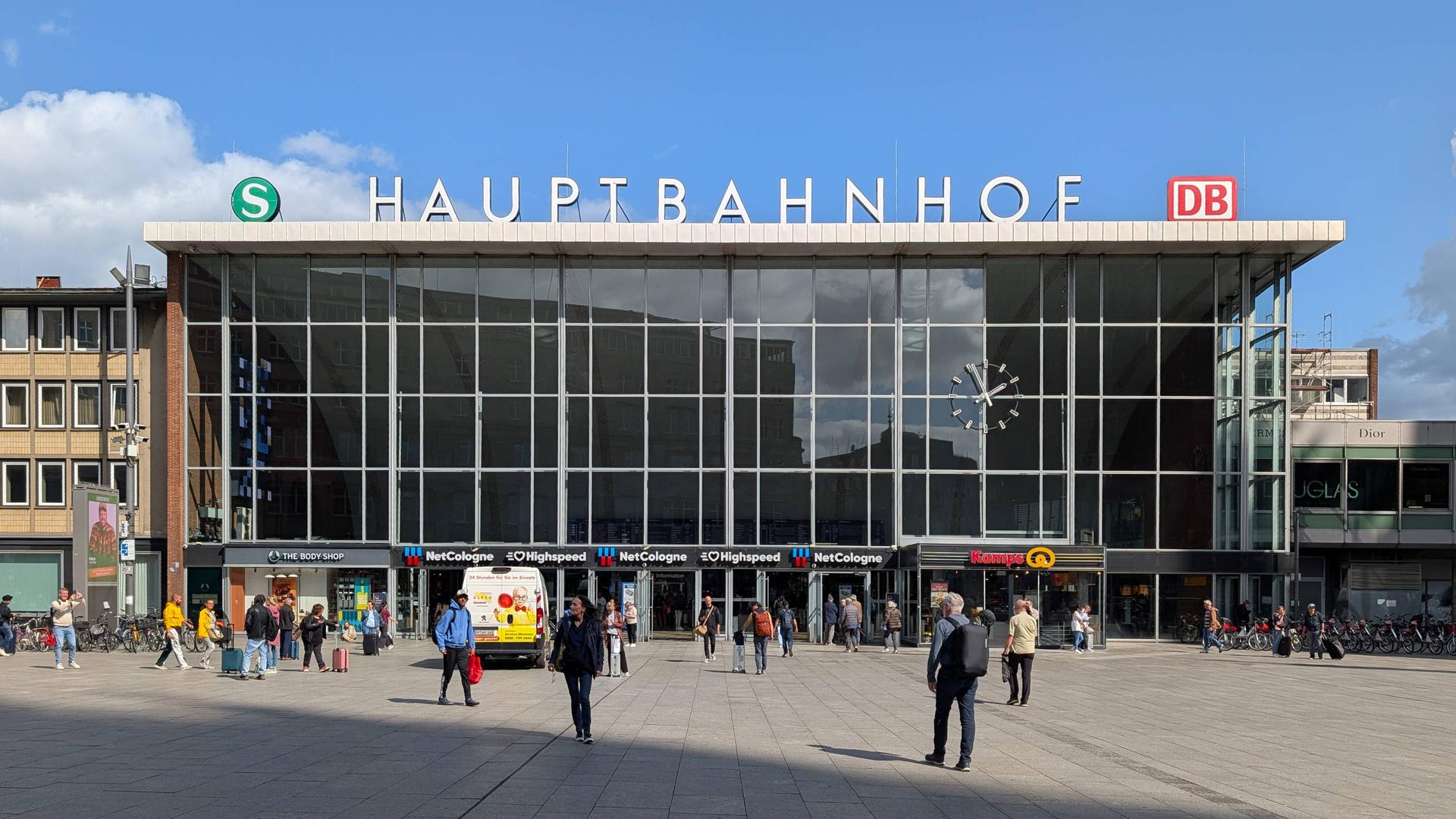 Der Kölner Hauptbahnhof mit dem Vorplatz, auf dem einige Menschen gehen.