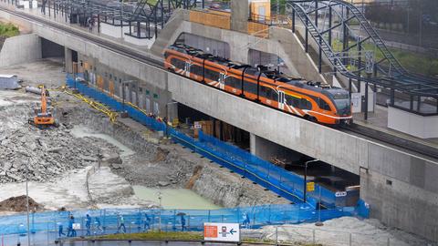 Teilstrecke der Zugverbindung "Rail Baltica" in Tallinn. Baustelle mit orangefarbenem Zug. 
