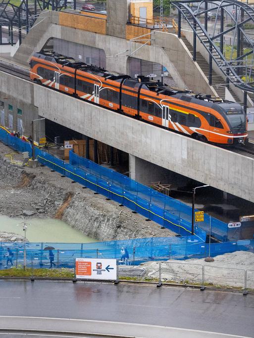 Teilstrecke der Zugverbindung "Rail Baltica" in Tallinn. Baustelle mit orangefarbenem Zug. Teilstrecke der Zugverbindung "Rail Baltica" in Tallinn. Baustelle mit orangefarbenem Zug.
