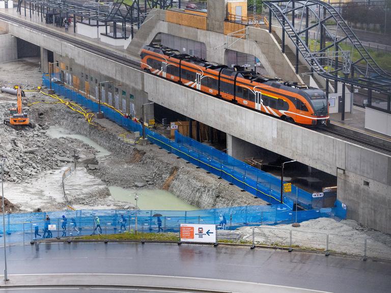 Teilstrecke der Zugverbindung "Rail Baltica" in Tallinn. Baustelle mit orangefarbenem Zug. Teilstrecke der Zugverbindung "Rail Baltica" in Tallinn. Baustelle mit orangefarbenem Zug.