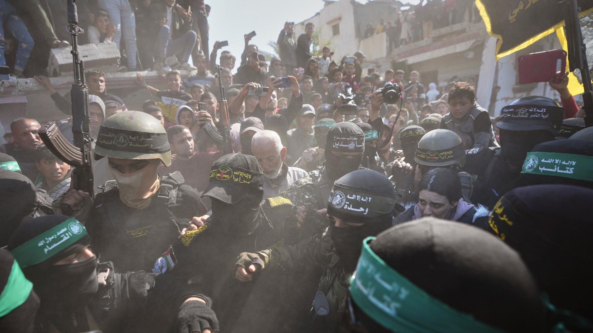 Die israelische Geisel Arbel Yehoud wird von Hamas-Kämpfern umringt während sie auf dem Weg zum Roten Kreuz in Chan Junis sind.