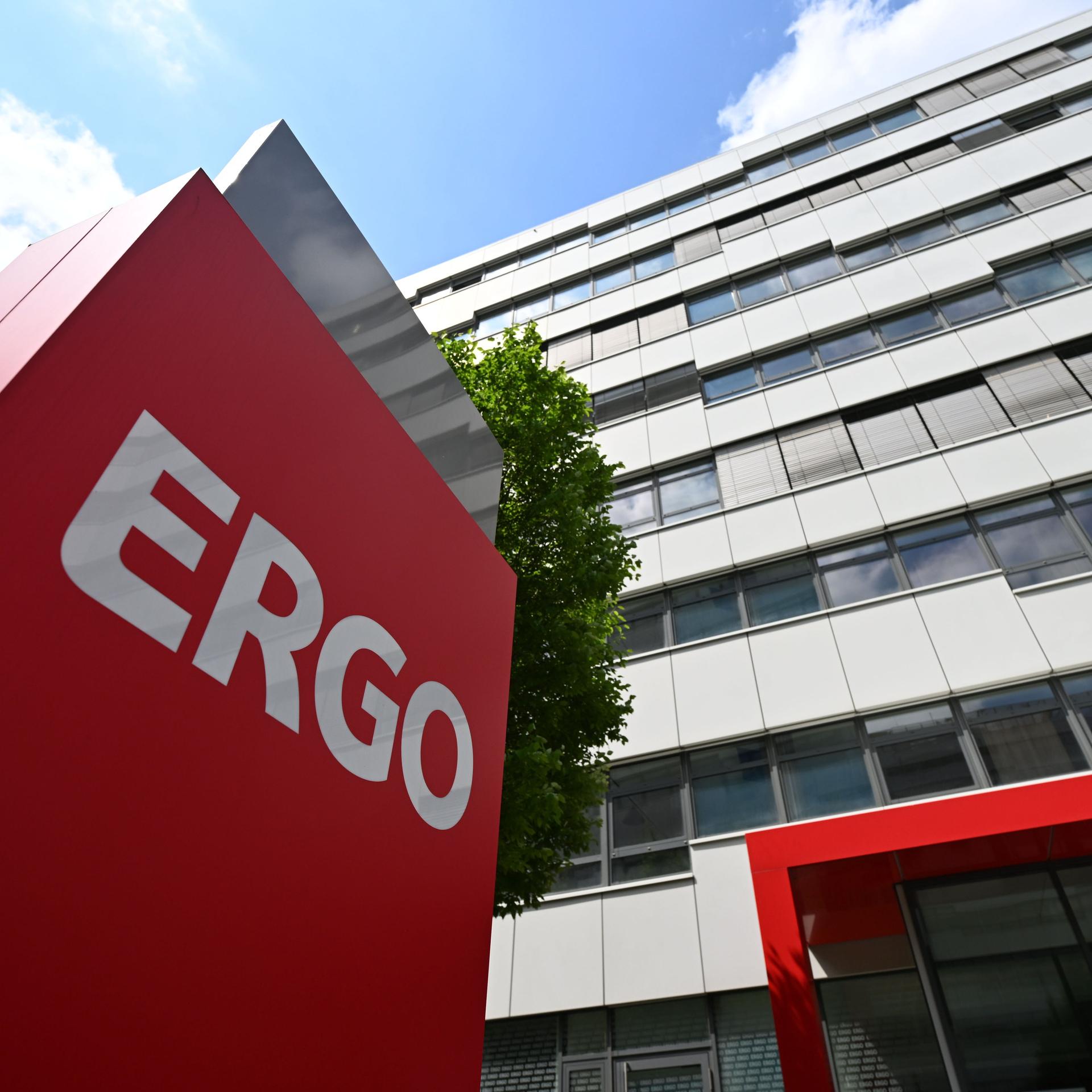 Vor einem hohen Gebäude steht ein rotes Schild mit der Aufschrift "Ergo".