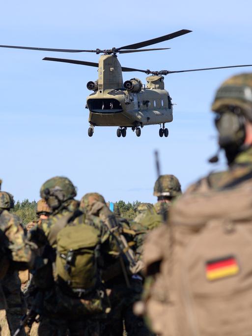 Soldaten des Falschirmjägerregiments 26 warten auf die Landung eines Chinook C-47 Hubschraubers der US-Army, der die Soldaten für eine Übung aufnehmen soll.