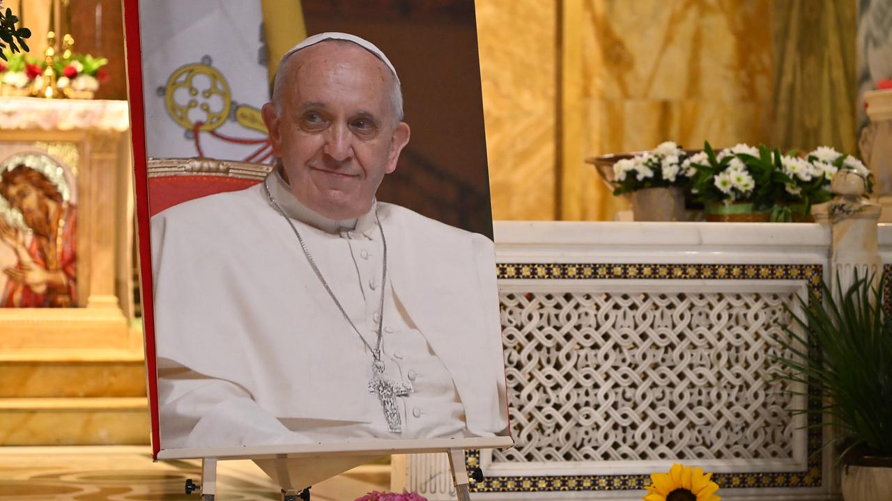 Ein Foto von Papst Franziskus steht auf einer Staffelei vor einem Marmoraltar.