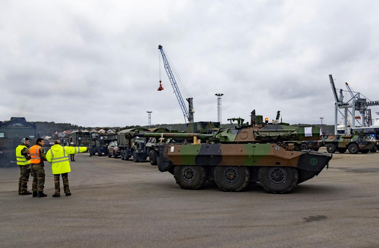 Panzer für ein Militärmanöver der Nato werden im Hafen von Fredrikstad in Norwegen von drei Männern angewiesen.