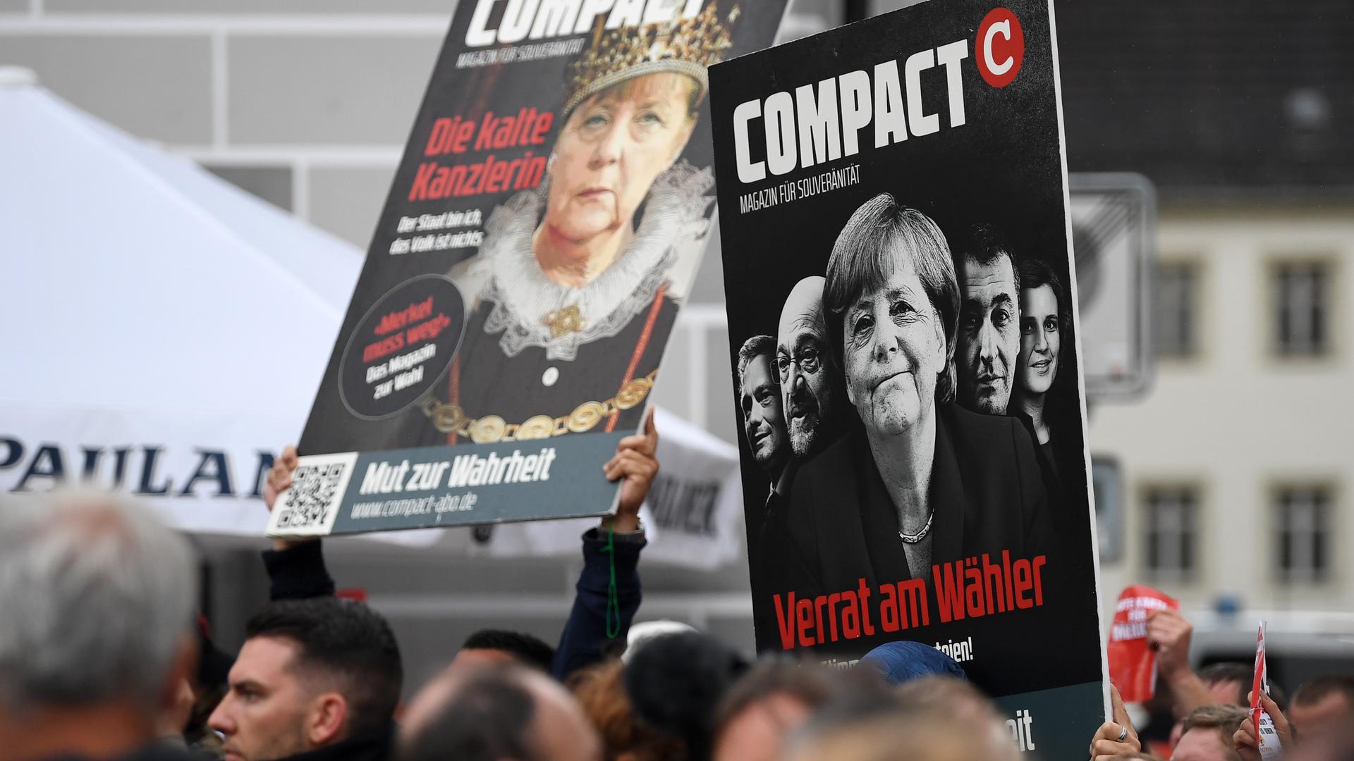 Bei Protesten 2017 halten Demonstranten Plakate in die Höhe, die Titelbilder des Magazins "Compact" mit Kritik an Angela Merkel zeigen.