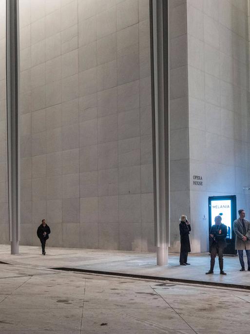 Das Foto zeigt das Eingangsportal des Kennedy-Centers in Washington. Menschen betreten es durch eine Eingangsschleuse.