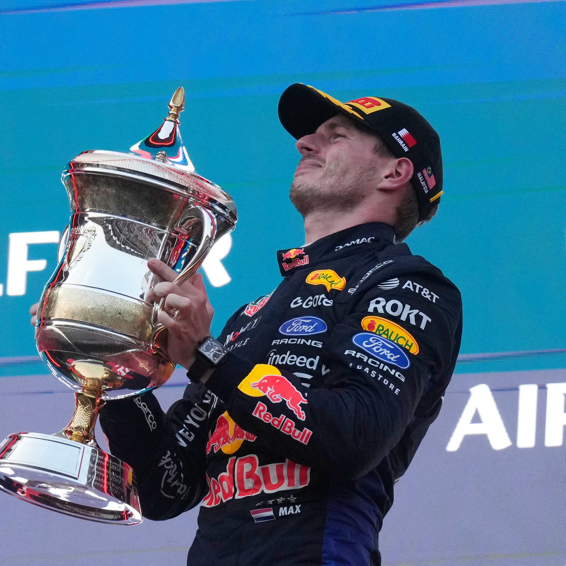 Red-Bull-Pilot Max Verstappen bei der Siegerehrung in Malaysia. Er hält seinen Pokal in die Höhe. 