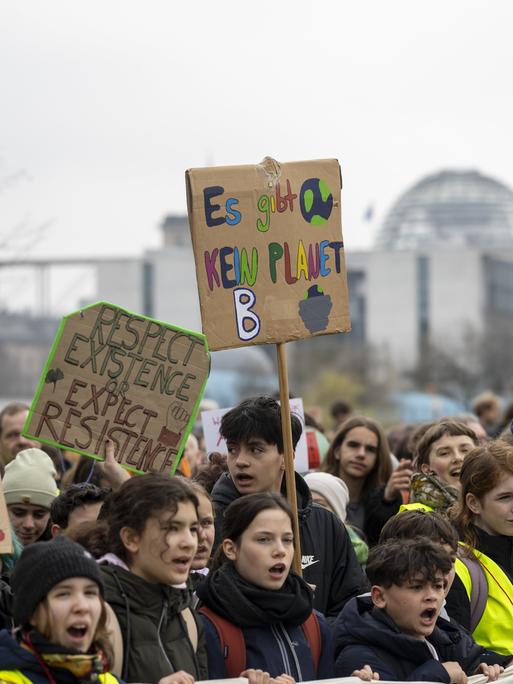 Streikende Jugendliche halten ein Plakat mit der Aufschrift "Es gibt kein Planet B" in die Höhe.