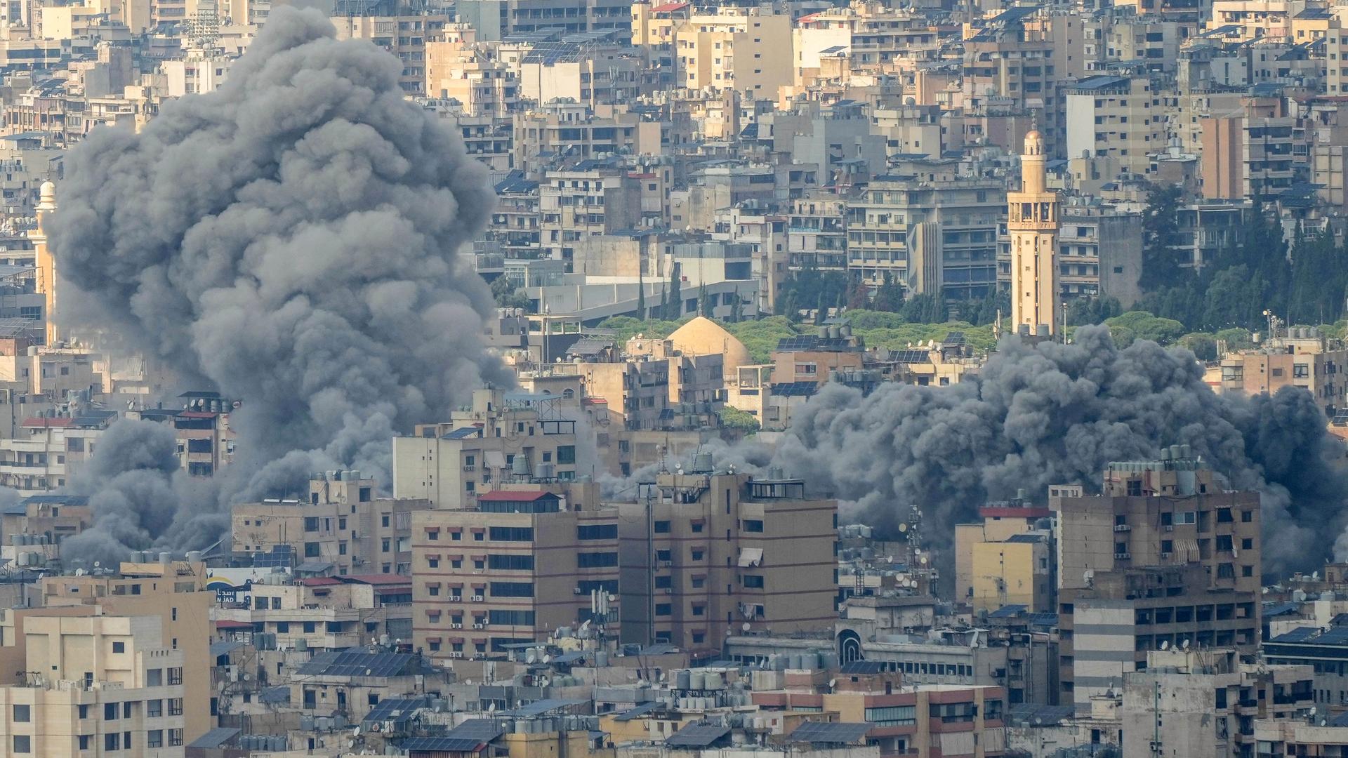 Rauch steigt über den Häusern einer Stadt im Libanon auf.