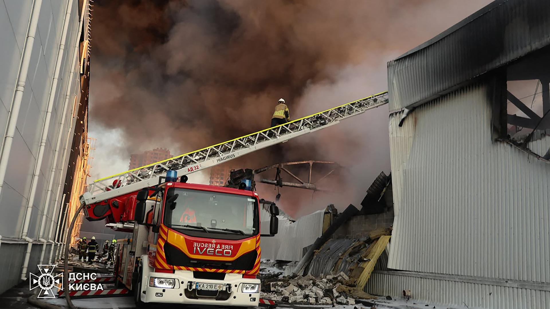Ukrainische Feuerwehrleute bei Löscharbeiten am Ort eines russischen Luftangriffs in Kiew während der russischen Invasion der Ukraine.