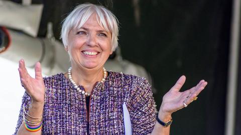 Claudia Roth lächelnd mit ausgebreiteten Armen.