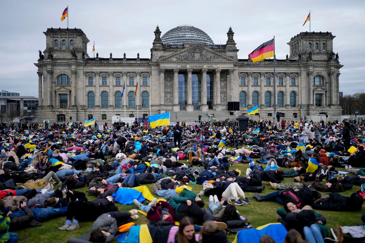 Demonstrierende vor dem Reichstagsgebäude liegen auf dem Boden, um an die getöteten Menschen durch Russlands Angriffskrieg gegen die Ukraine zu erinnern.