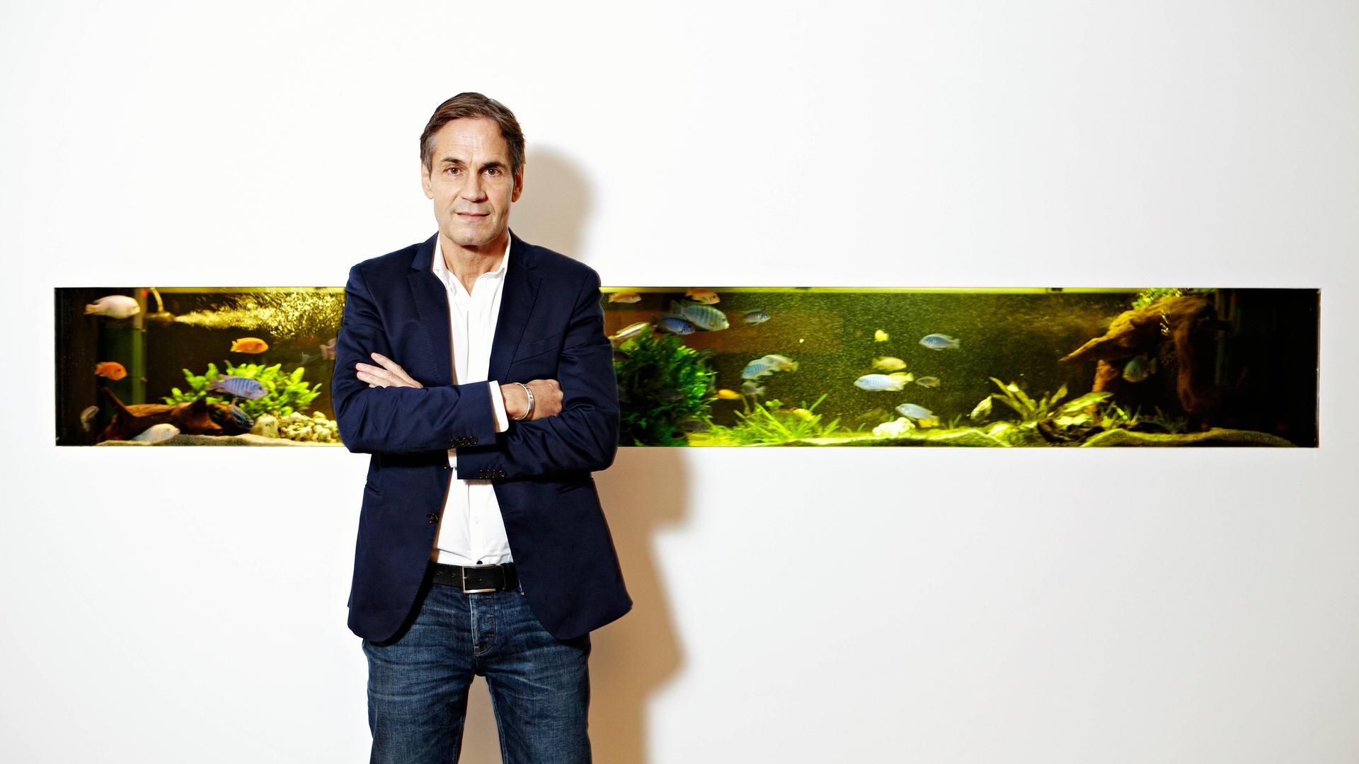 Jean Remy von Matt vor dem Aquarium der Werbeagentur Jung von Matt in der Glashüttenstrasse in Hamburg. Das Aquarium ist in eine sonst komplett weiße Wand eingebettet. Jean Remy von Matt vor dem Aquarium der Werbeagentur Jung von Matt in der Glashüttenstrasse in Hamburg. Das Aquarium ist in eine sonst komplett weiße Wand eingebettet.