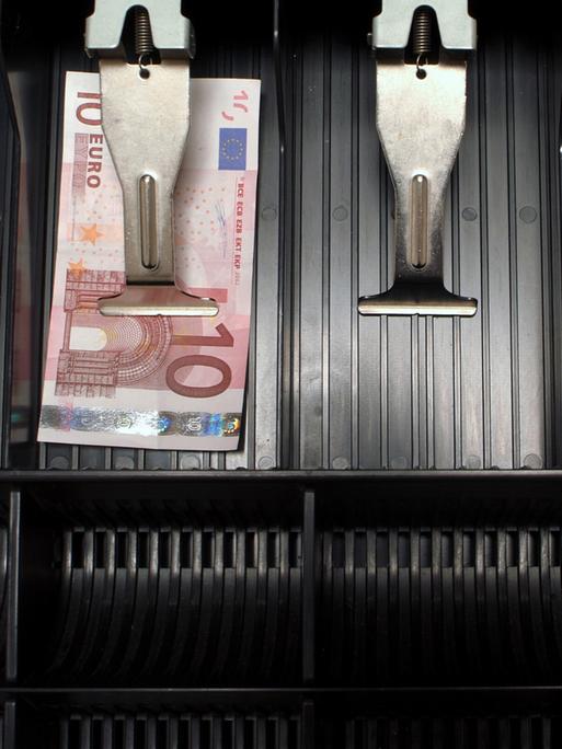In einer ansonsten leere Kasse liegt ein einzelner Zehn-Euro-Schein. In einer ansonsten leere Kasse liegt ein einzelner Zehn-Euro-Schein.