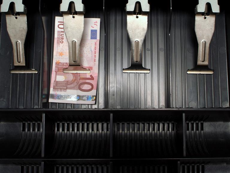 In einer ansonsten leere Kasse liegt ein einzelner Zehn-Euro-Schein. In einer ansonsten leere Kasse liegt ein einzelner Zehn-Euro-Schein.