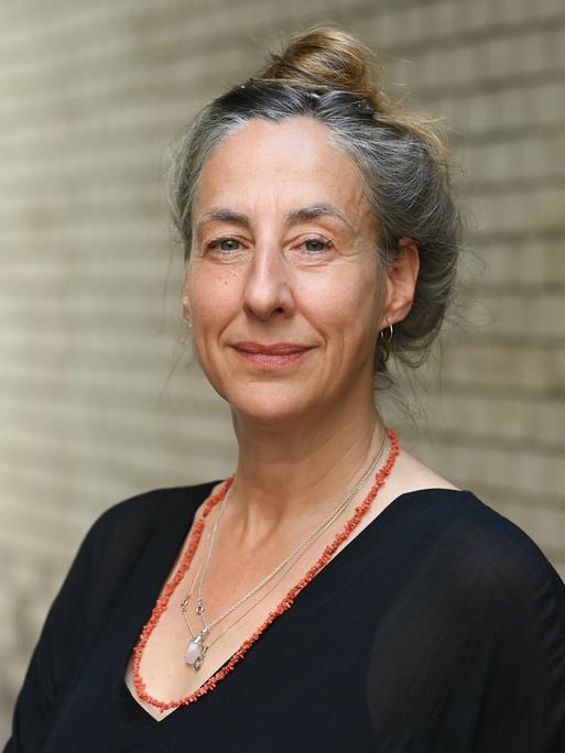 Die Schriftstellerin Judith Hermann steht bei einem exklusiven dpa-Fototermin in einem Hof, der zu Räumlichkeiten des S. Fischer Verlags führt.