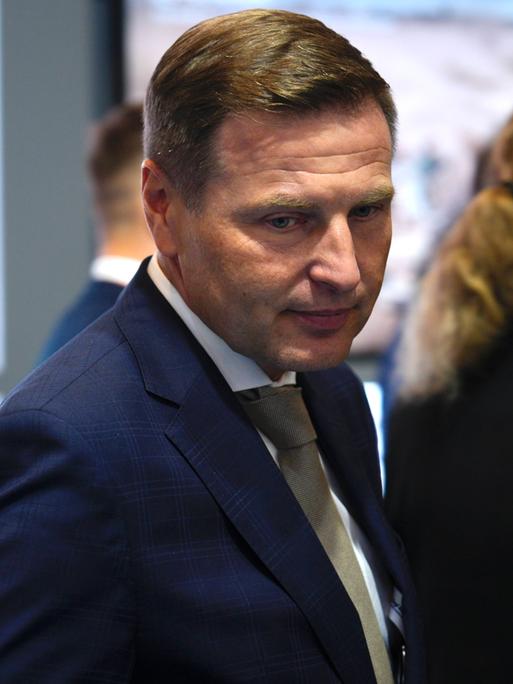 Estlands Verteidigungsminister Hanno Pevkur besucht eine Verteidigungsmesse in Polen. Er ist in der Halbtotalen zu sehen und trägt einen blauen Anzug.