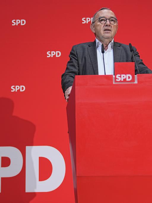 Der SPD-Co-Bundesvorsitzende Norbert Walter-Borjans vor einer roten Wand mit dem Logo der SPD