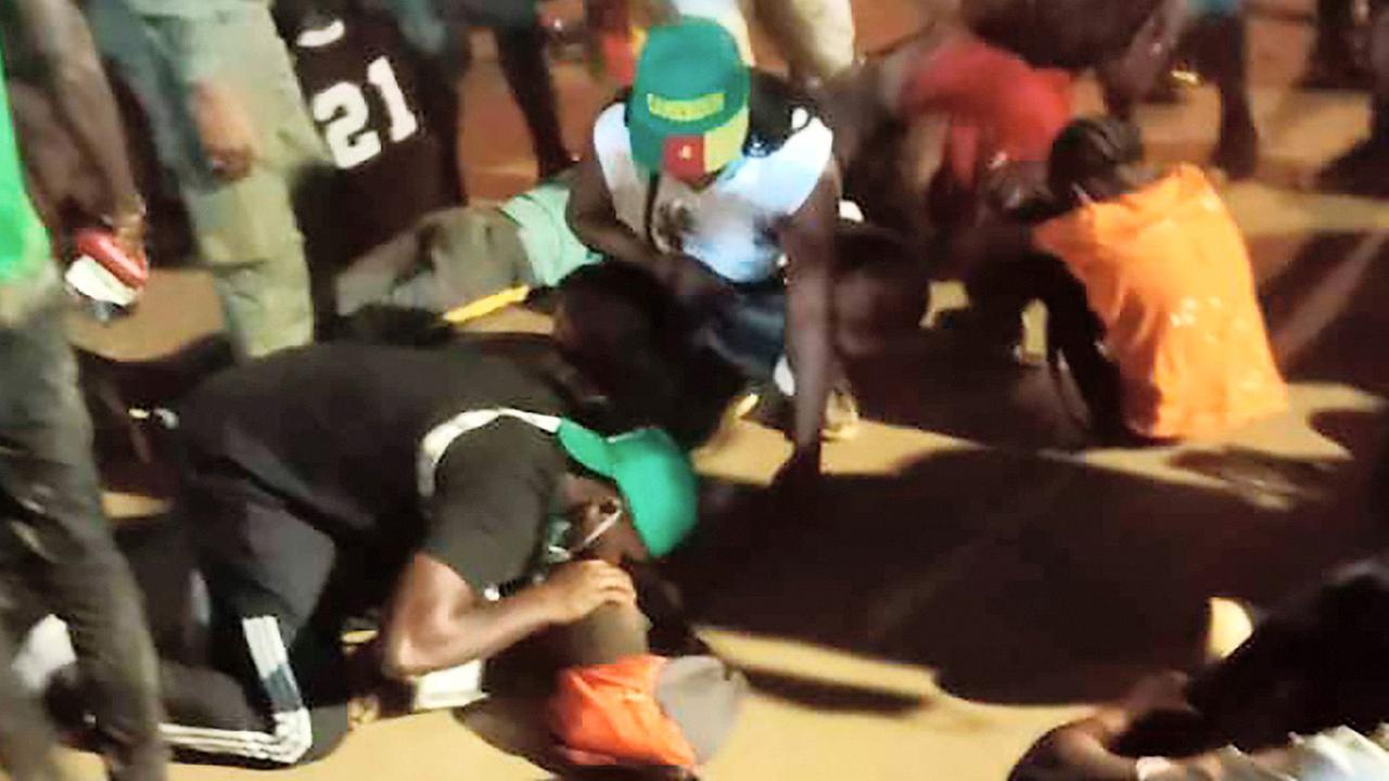 Menschen helfen den Opfern von einer Massen-Panik vor einem Stadion in der Stadt Janúnde in Kamerun.