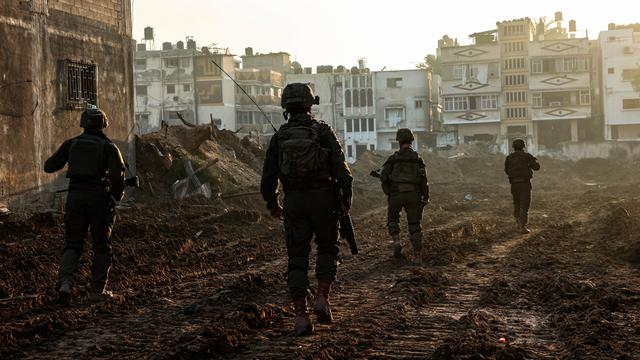 Israelische Soldaten laufen im Gazastreifen an zerstörten Gebäuden vorbei.