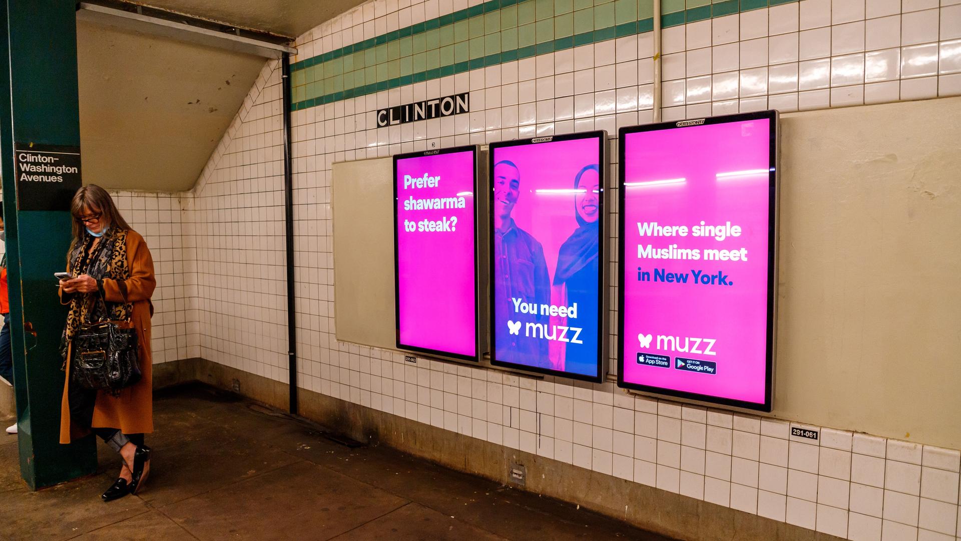 Pinke Plakate mit einem muslimischen Paar und der Aufschrift "Where single Muslims meet in New York" hängen auf einem New Yorker U-Bahnhof.