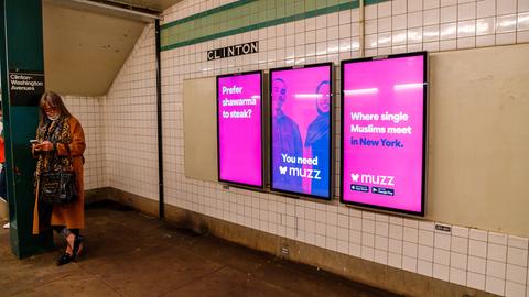 Pinke Plakate mit einem muslimischen Paar und der Aufschrift "Where single Muslims meet in New York" hängen auf einem New Yorker U-Bahnhof.