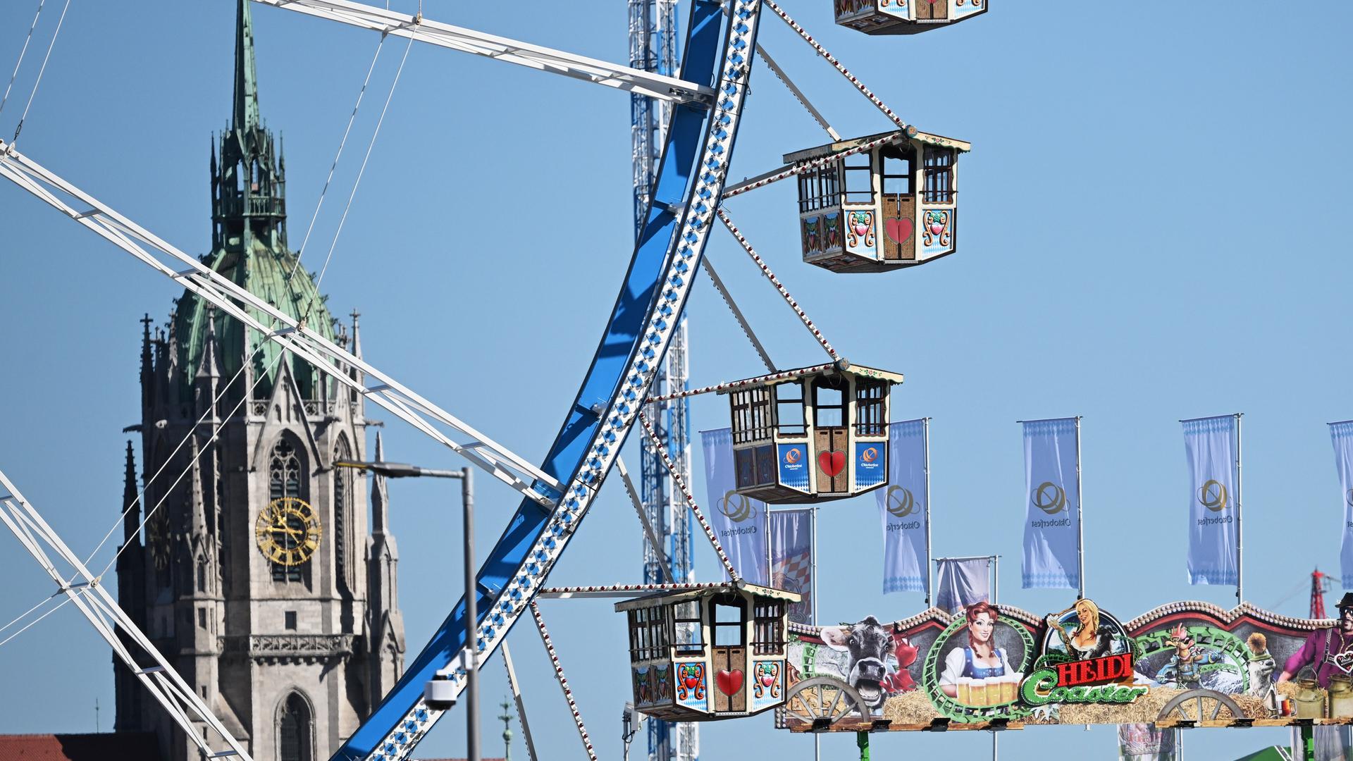 Ein Riesenrad auf dem Oktoberfestgelände, dahinter die Kirche St. Paul