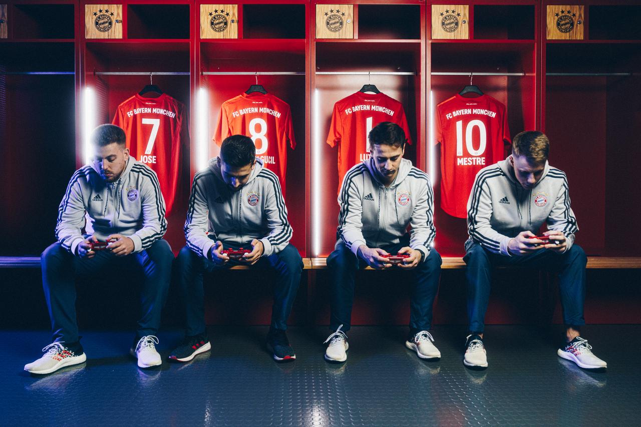 Die Spieler der 2019 von Bayern München gegründeten eSports Mannschaft sitzen auf einer Bank in der Umkleide, im Hintergrund hängen ihre Spielertrikots.