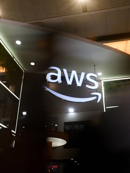Das Logo AWS, was für Amazon Web Services steht, leuchtet auf einem Messestand